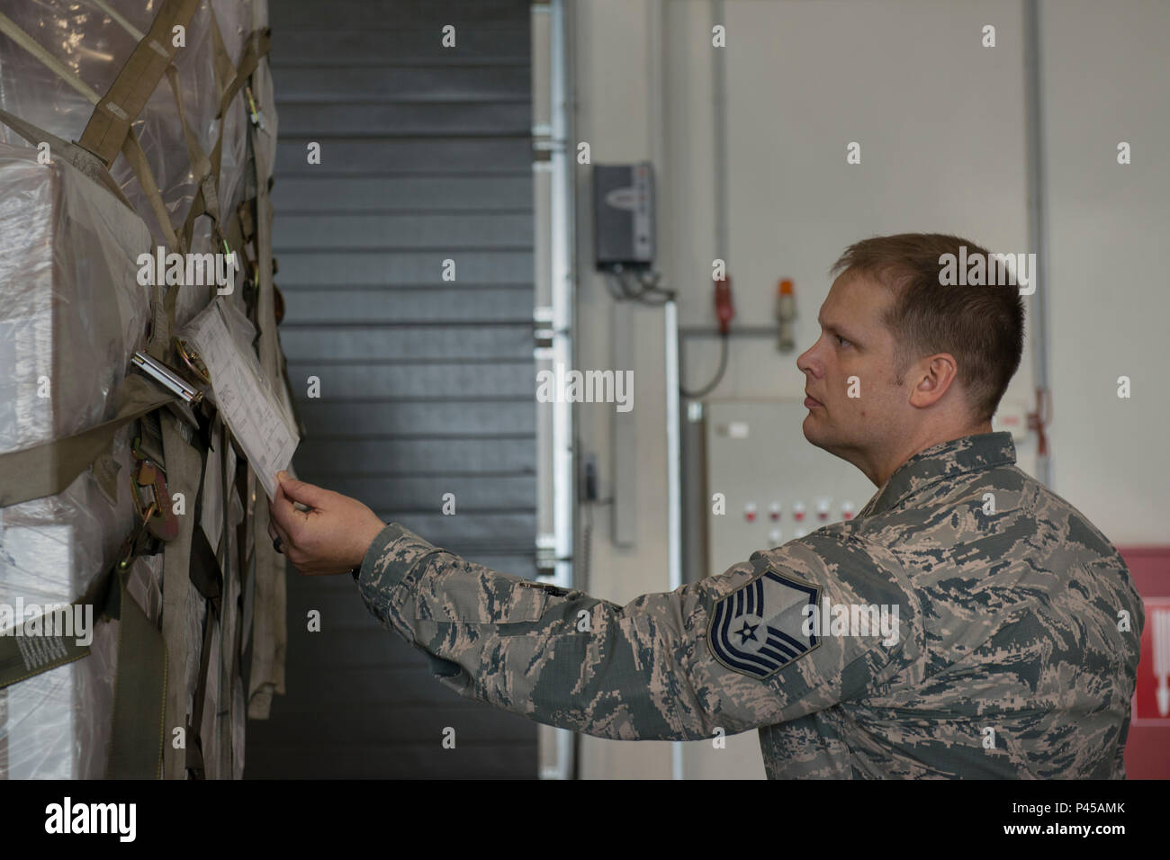 Master Sgt. Ryan corazza, 721st porta antenna squadrone soprintendente di sicurezza, controlla le informazioni di sicurezza su un pallet 28 giugno 2016, a Ramstein Air Base, Germania. Avieri dal 721st APS spesso uso di carrelli elevatori a forche e carico carico pesante in grandi velivoli, e l'ufficio di sicurezza aiuta a prevenire lesioni personali o danni alle apparecchiature. (U.S. Air Force foto/Airman 1. Classe Tryphena Mayhugh) Foto Stock