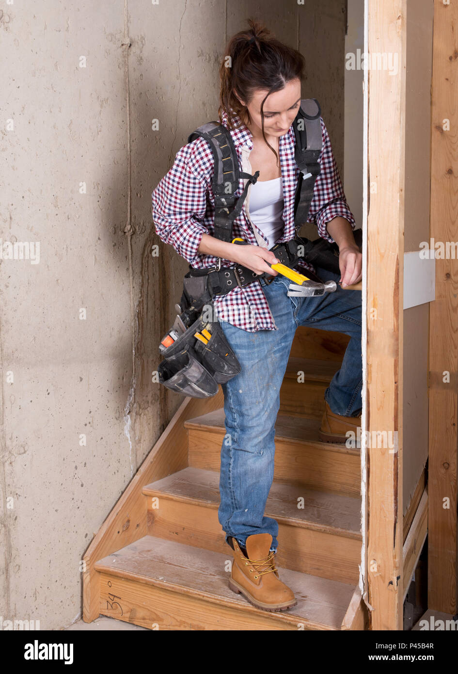 Costruzione femmina lavoratore con un martello presso il sito Foto Stock