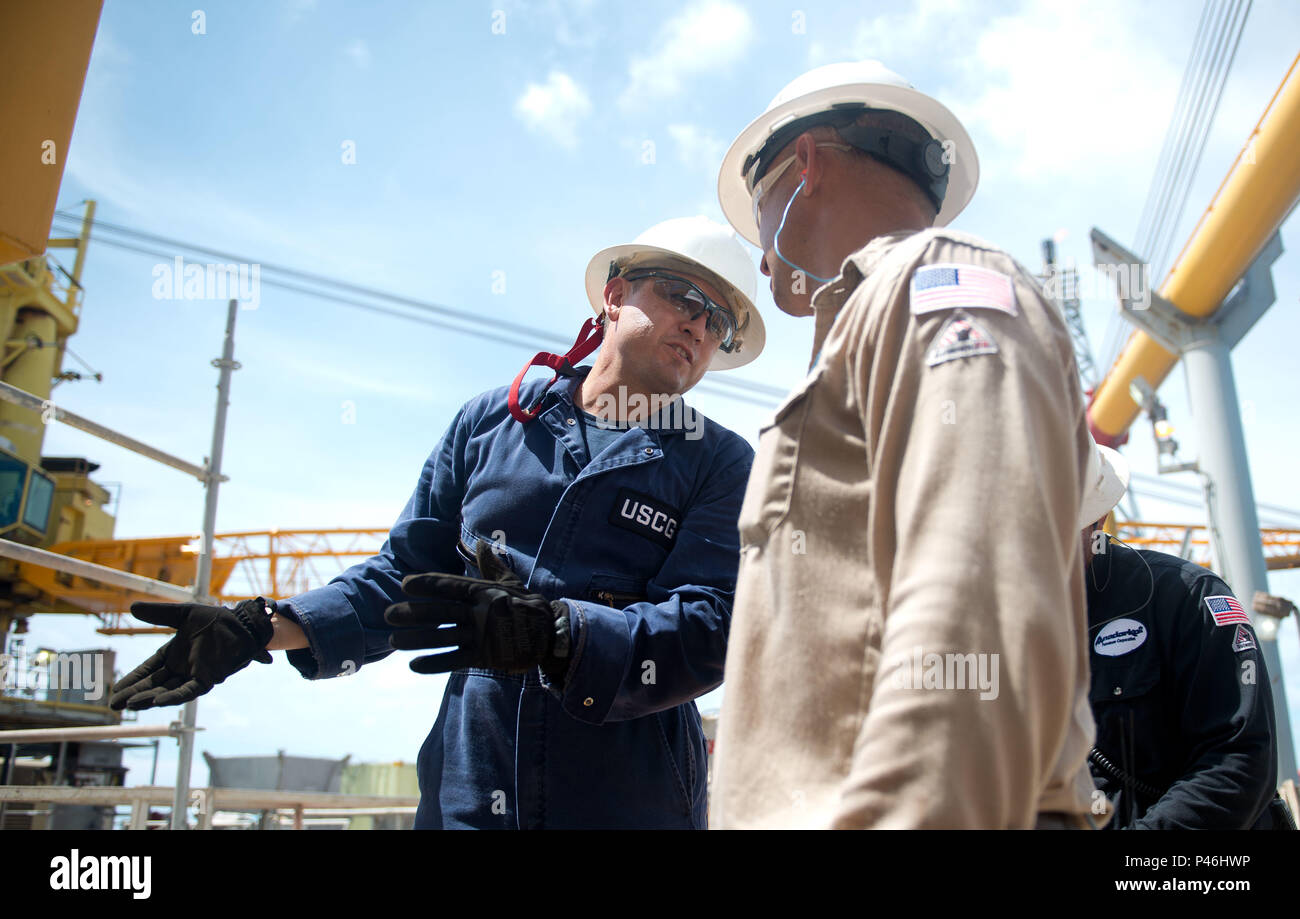 Chief Warrant Officer Eddie Martinezlopez funziona con un dipendente durante la ispezione di una piattaforma di olio di circa 160 miglia fuori Galveston, Texas, 28 giugno 2016. Ispezionare le piattaforme petrolifere assicura alle aziende sono in seguito la giusta sicurezza proceedures e rimanendo nella protezione ambientale linee guida. Stati Uniti Coast Guard foto di Sottufficiali di terza classe Dustin R. Williams Foto Stock