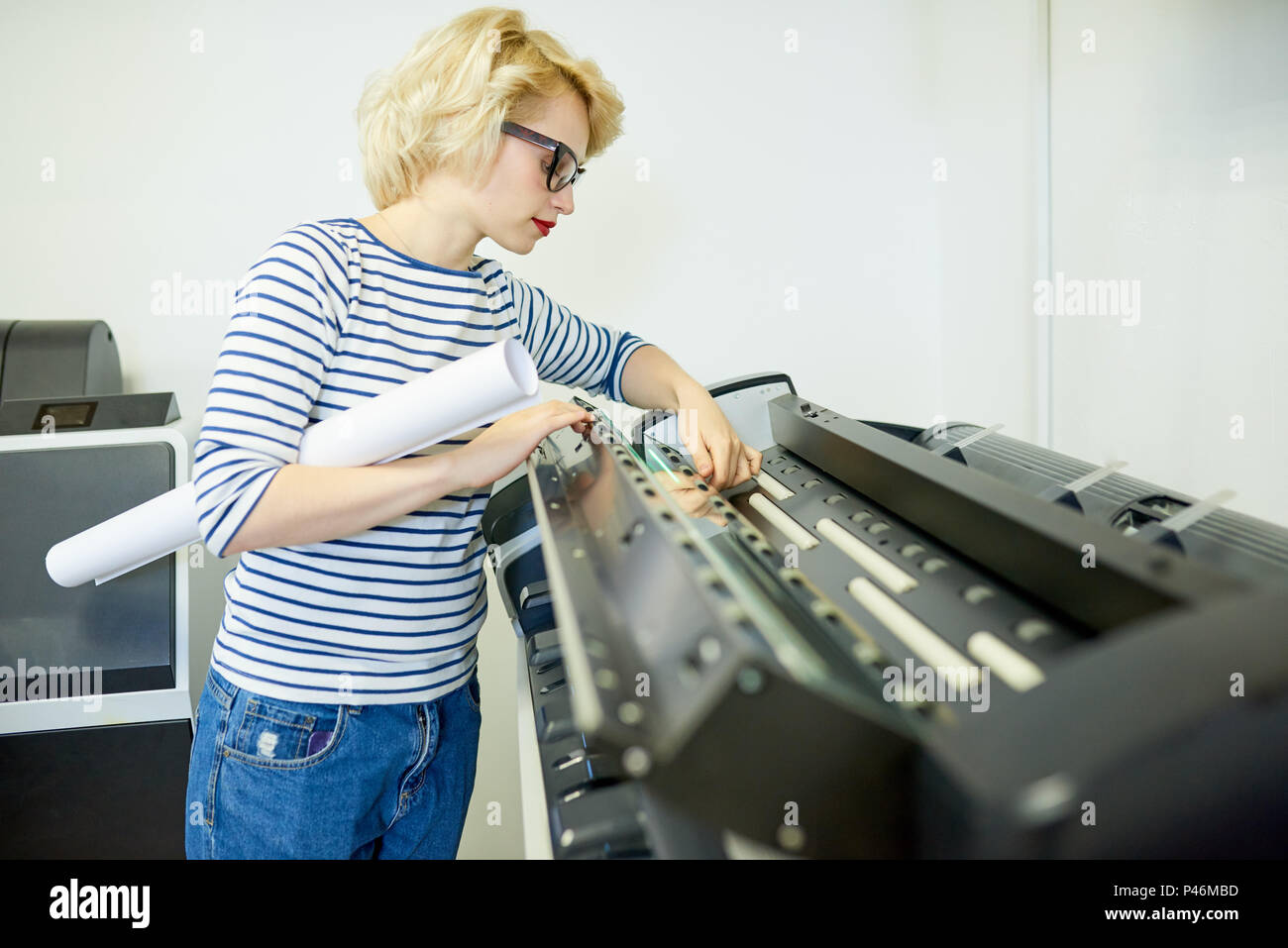 Donna con rotolo di carta controllo stampante Foto Stock