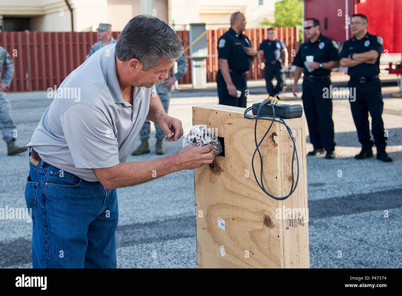 Il Bret Stohr, internamente il servizio antincendio e consulente di U.S. Air Force pensionato operazioni assistente capo, pacchi giornale in un legno brucia prop prima di una dimostrazione di ventilazione a base comune San Antonio-Randolph Giugno 22, 2016. La formazione è stata data a quaranta studenti, compresi i membri dal JBSA Vigili del Fuoco, Universal City Fire Department, Live Oak dei Vigili del fuoco e del 902nd delle forze di sicurezza Squadron qui. Foto Stock