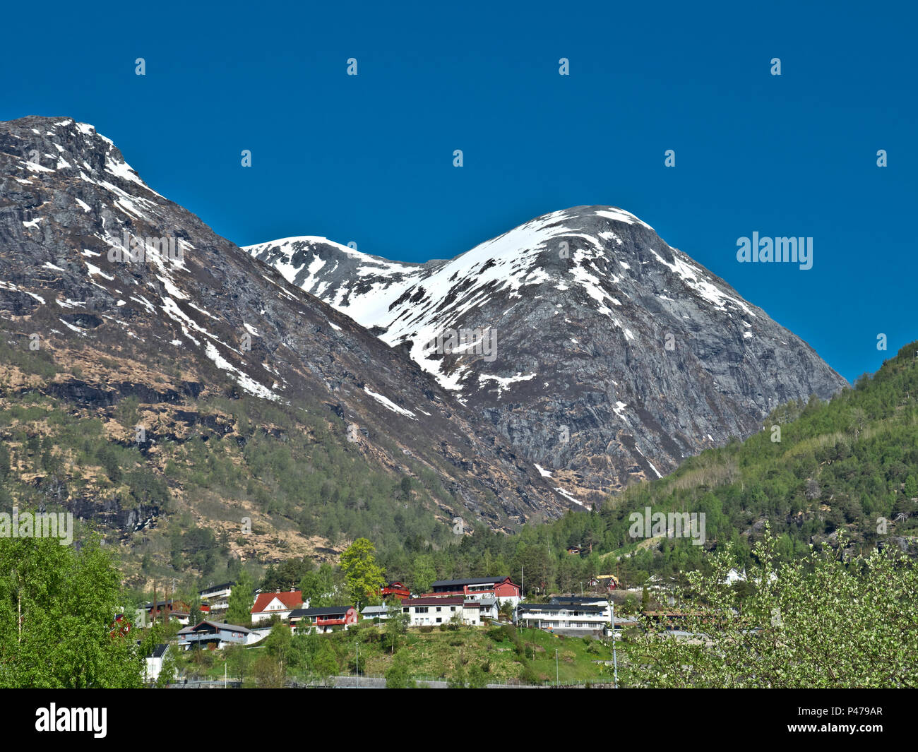 Bella panoramica splendido paesaggio montuoso di fiordi norvegesi area con verde primavera gli alberi & montagne innevate vette. Foto Stock