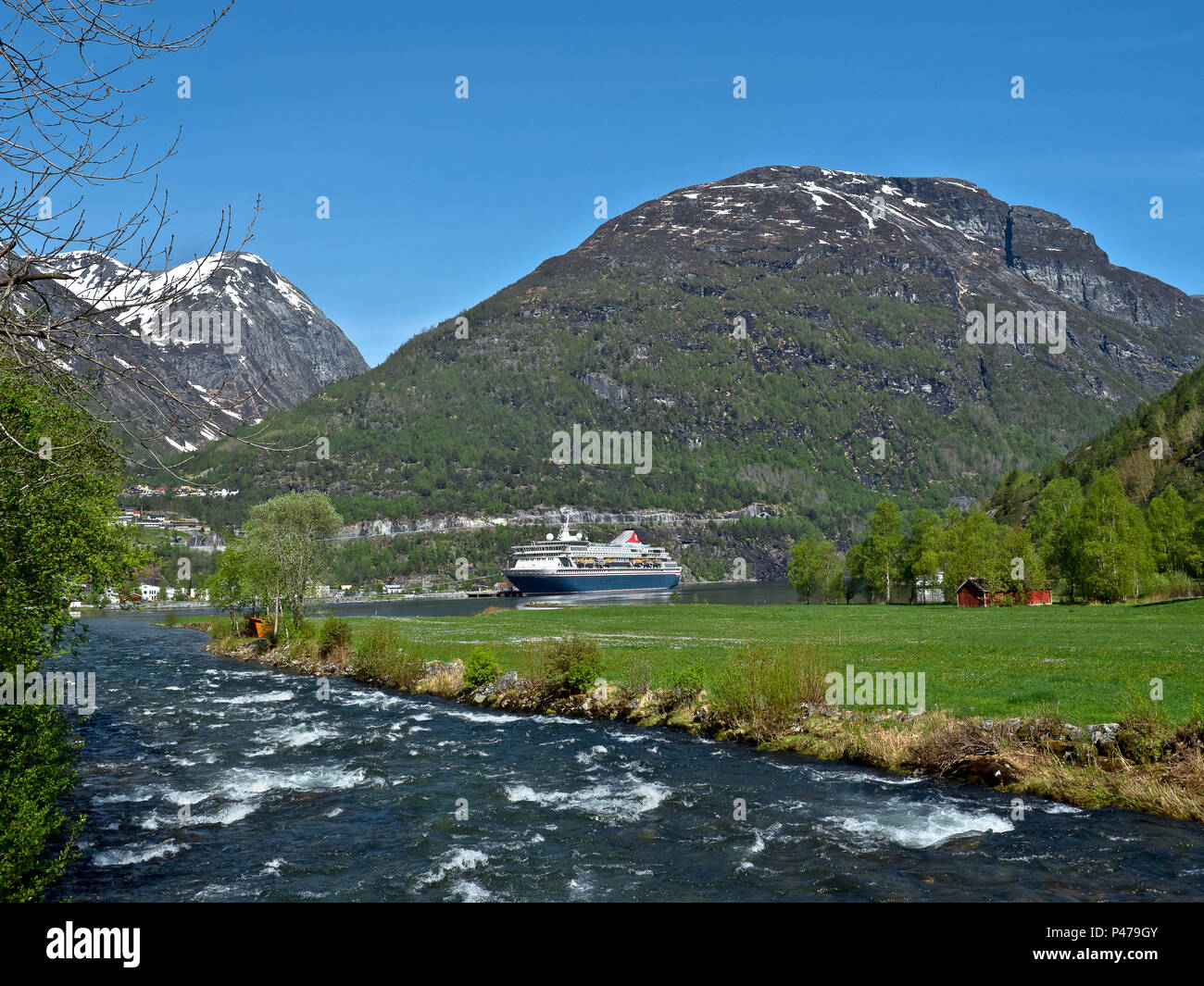 Bella panoramica splendido paesaggio montuoso di fiordi norvegesi area con verde primavera gli alberi & montagne innevate vette. Foto Stock