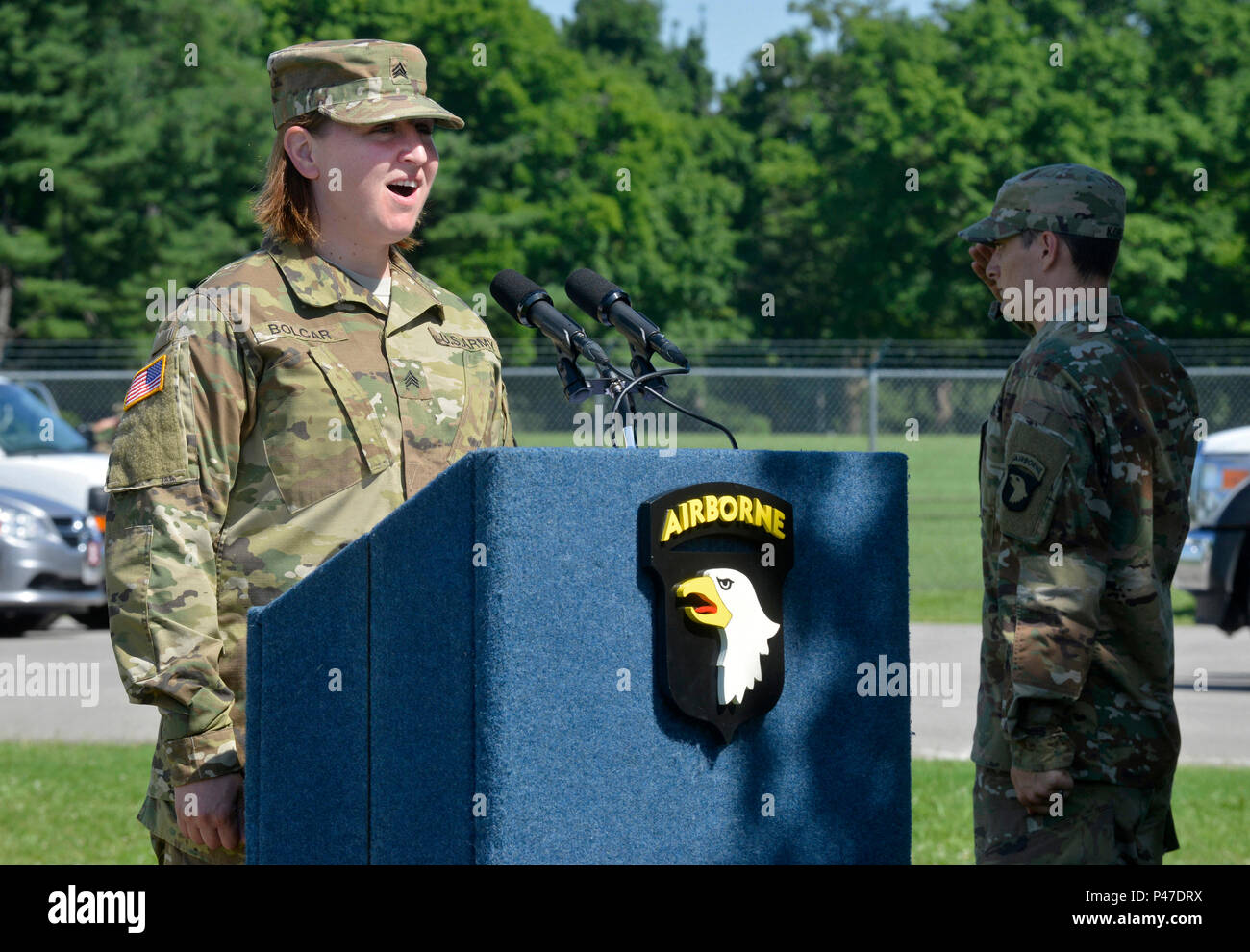 Stati Uniti Army Sgt. Katherine Bolcar, cantante per la 101ª Divisione aviotrasportata band canta l'inno nazionale presso il cancello 4 memorialization cerimonia su Fort Campbell, Ky., 28 giugno 2016. Gate 4 è stata rinominata in onore di Clarissa Ann Jackson "T.C." Freeman che era un civile Aide al Segretario dell'esercito per Central Kentucky e straordinaria sostenitore dell'esercito e Fort Campbell per 30 anni. Gate 4 sarà ora noto come la T.C. Freeman Gate. "T.C." è scomparso il 19 maggio 2016 all'età di 83. (U.S. Foto dell'esercito da Sam Shore/rilasciato) Foto Stock