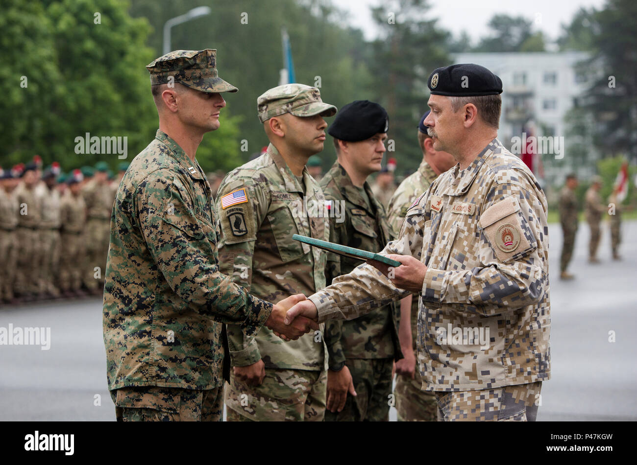 Con una mano scuotere gli alleati della NATO mostrano il loro impegno per la difesa collettiva dell'Europa come essi difendono la fiducia, rispetto, equilibrio, e l'uguaglianza, la Lettonia. (U.S. Marine Corps foto di Cpl. Kelly L. Street, 2D MARDIV COMCAM/RILASCIATO) lettone Brig. Gen. Ainars Ozolins, il direttore di esercizio per esercizio Saber Strike 16, scuote le mani con U.S. Marine Corps Capt. Jonathan R. Blankenship, un comandante di compagnia con il Mar Nero forza rotazionale, riconoscendo in lui durante la cerimonia di chiusura per esercitare Saber Strike 16, Adazi Base Militare, Lettonia, 21 giugno 2016. Unità tra alleati assicura il collettivo d Foto Stock