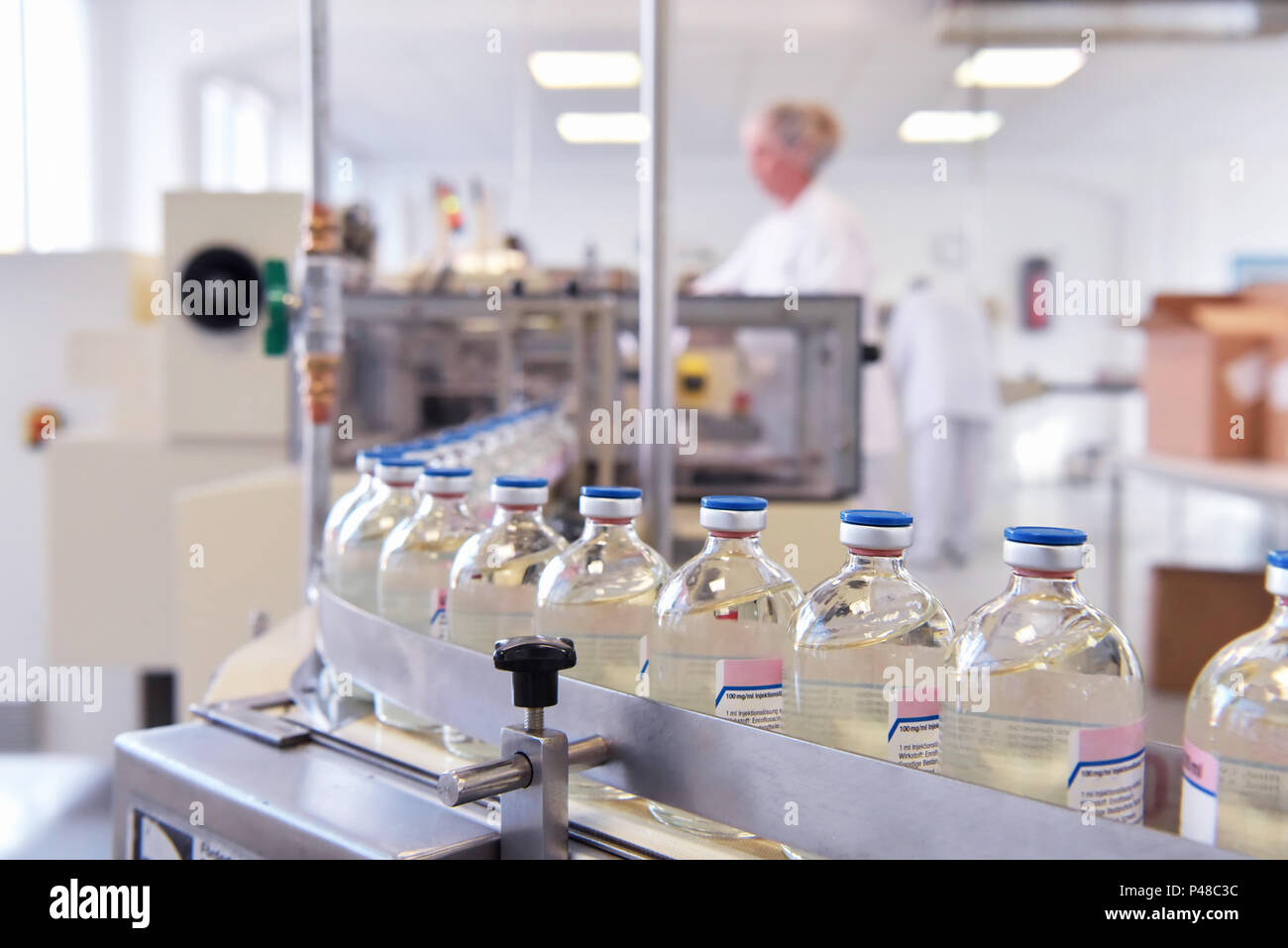 Lavorazione ed imbottigliamento di farmaci in un impianto di produzione farmaceutica - nastro trasportatore con bottiglie Foto Stock
