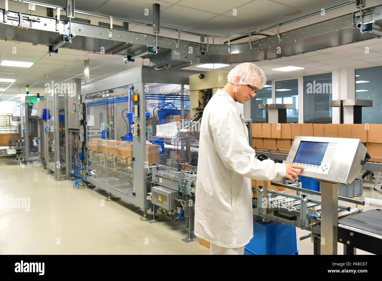 Nastro trasportatore lavoratore opera un robot che trasporta i sacchetti di insulina - moderno stabilimento per la produzione di medicinali nel settore sanitario Foto Stock