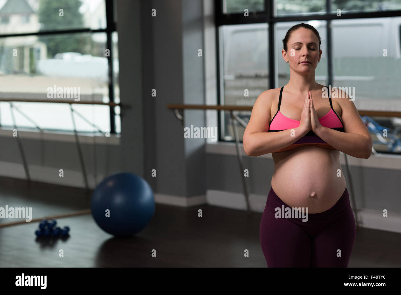 Donna incinta di eseguire lo yoga Foto Stock
