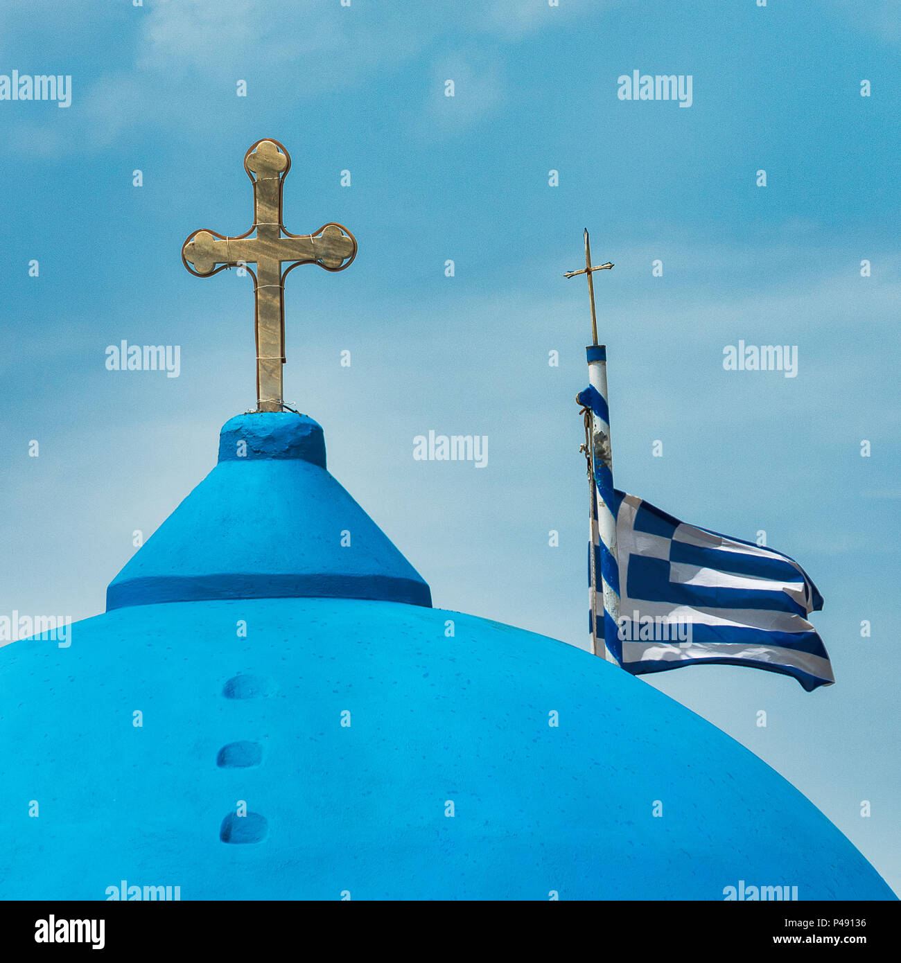 Cupola blu e croce su una chiesa ortodossa greca con la bandiera greca sul Mar Egeo Isola di Santorini, Grecia Foto Stock