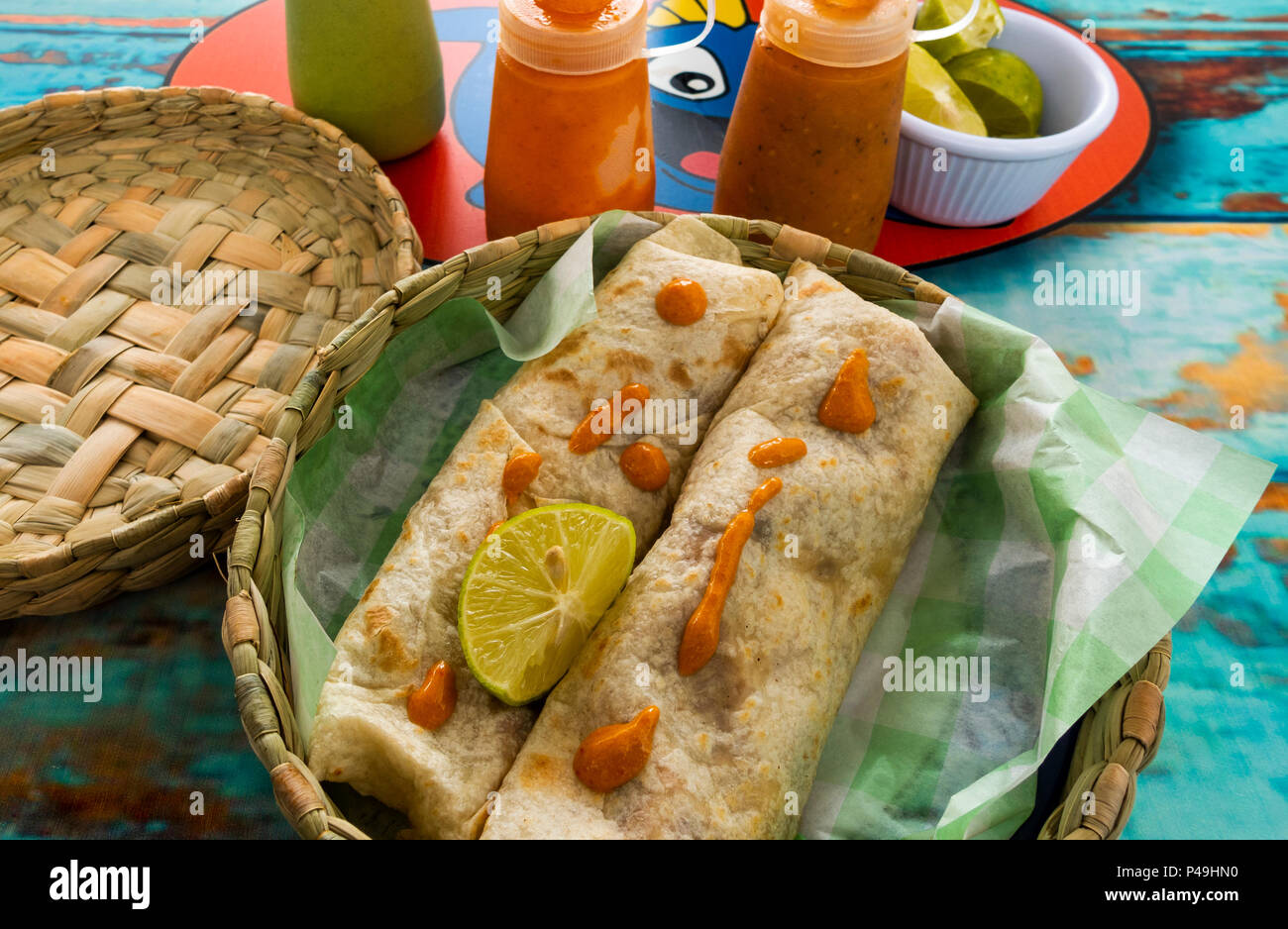 Due burrito di gamberetti in un cesto su una tavola dipinta a Baja Taquito pesce ristorante in San Miguel De Allende Foto Stock