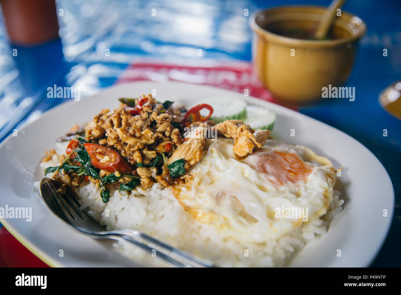Thai pasto semplice. Cucina di strada in Thailandia di riso al gelsomino con stir-fritto di pollo e foglia di basilico con uovo fritto piccante e speziato tipico piatto. Foto Stock