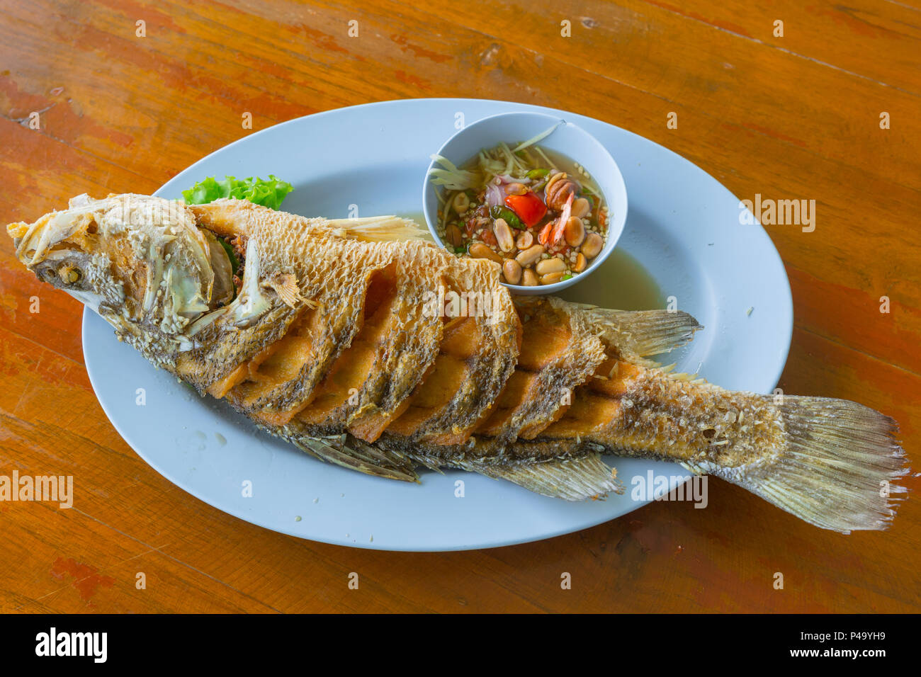 Mare tailandese cibo pesci fritti con dip piccante suace servita sulla tavola di legno. Foto Stock