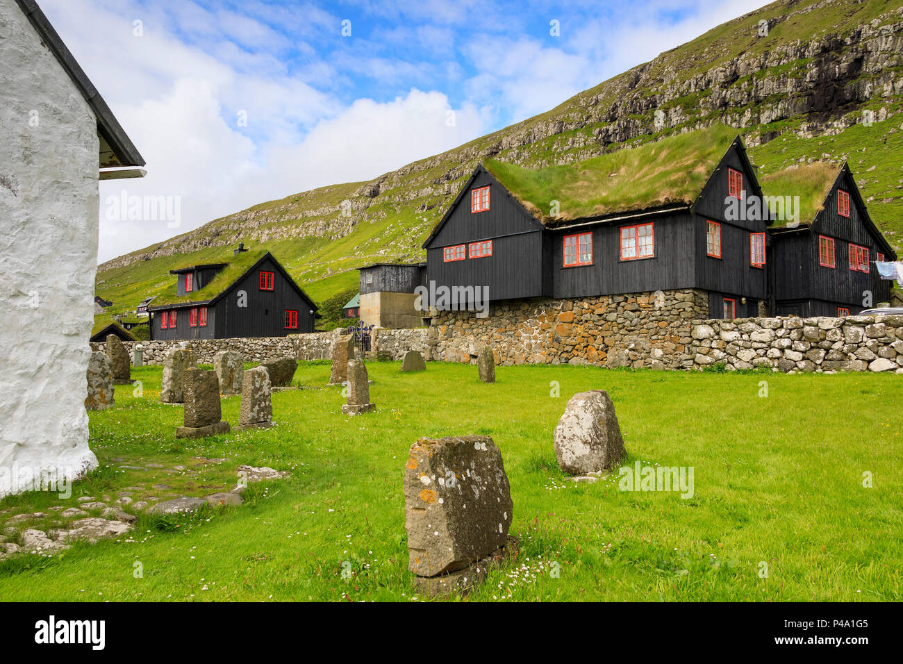 Case tradizionali con tetto di erba e il cimitero, Kirkjubour, Streymoy isola, isole Faerøer, Danimarca Foto Stock