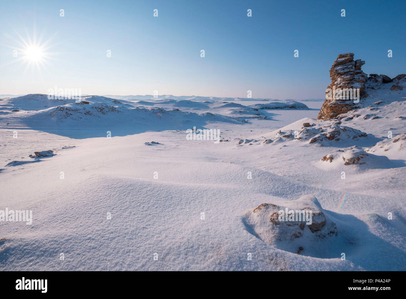 Rocce sotto la neve sul capo Uyuga, il lago Baikal, Regione di Irkutsk, Siberia, Russia Foto Stock