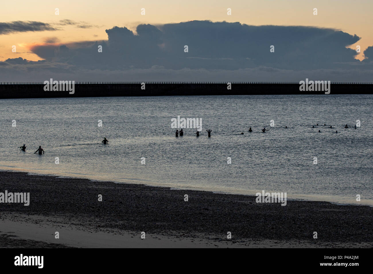 Sunderland, Regno Unito. Il 21 giugno, 2018. Solstizio d'estate sunrise. Una bella mattina nel Regno Unito, il meteo è calma per ora. Nuotatori prendere un tuffo nel mare del Nord come Dawn comincia a rompersi Credito: Dan Cooke/Alamy Live News Foto Stock