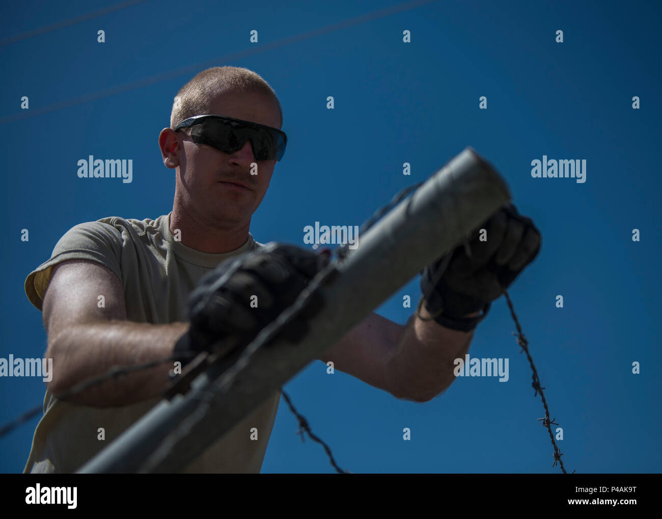 1Lt. Contrassegnare Bohme, 455th Expeditionary ingegnere civile squadrone tecnico di progetto, unclips barb filo da un palo da recinzione durante una demolizione, 22 giugno 2016, Bagram Airfield, Afghanistan. Gli ingegneri di sviluppo pianificare, organizzare e implementare sistemi di ingegneria dei processi nonché di identificare e di incorporare nuove tecnologie. (U.S. Air Force foto di Senior Airman Justyn M. Freeman) Foto Stock