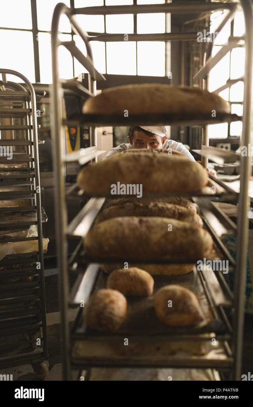 Il panettiere di sesso maschile che lavorano in baker shop Foto Stock