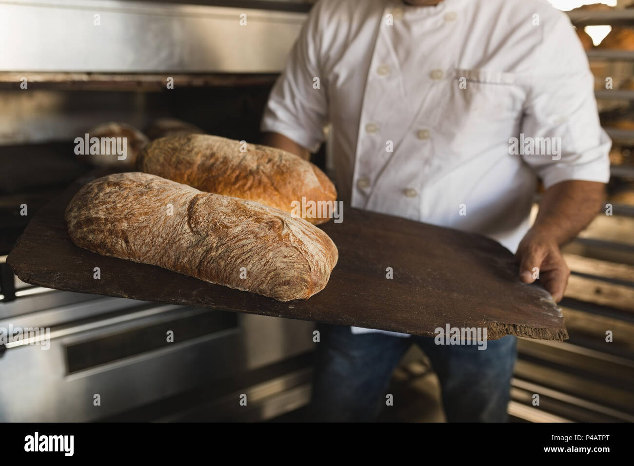 Voce maschile baker holding pane cotto in un panificio Foto Stock