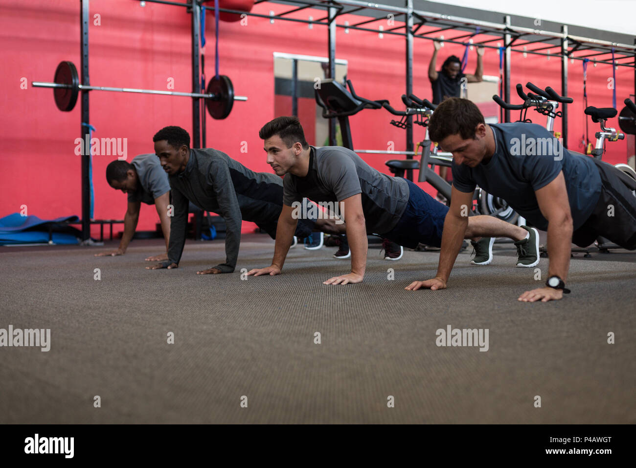 Gli atleti facendo spingere fino in palestra Foto Stock