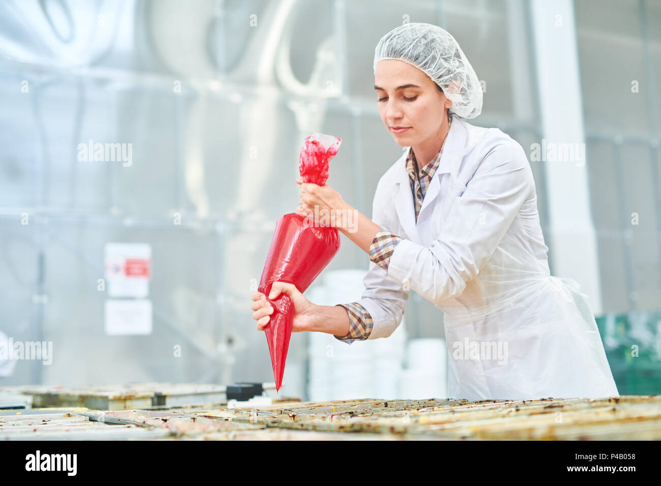 Pasticceria dipendente della fabbrica la spremitura di sacca di tela da pasticceria Foto Stock