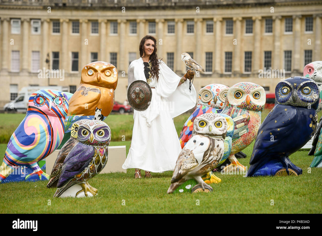 Un gufo siede in mano a una donna vestita come la dea romana Minerva, spesso chiamata gufo di Atena o gufo di Minerva, come si trova con alcune delle sculture di Owls of Bath di Minerva, Un percorso artistico che si svolge in città per tre mesi a partire dal 25 giugno 2018. Foto Stock