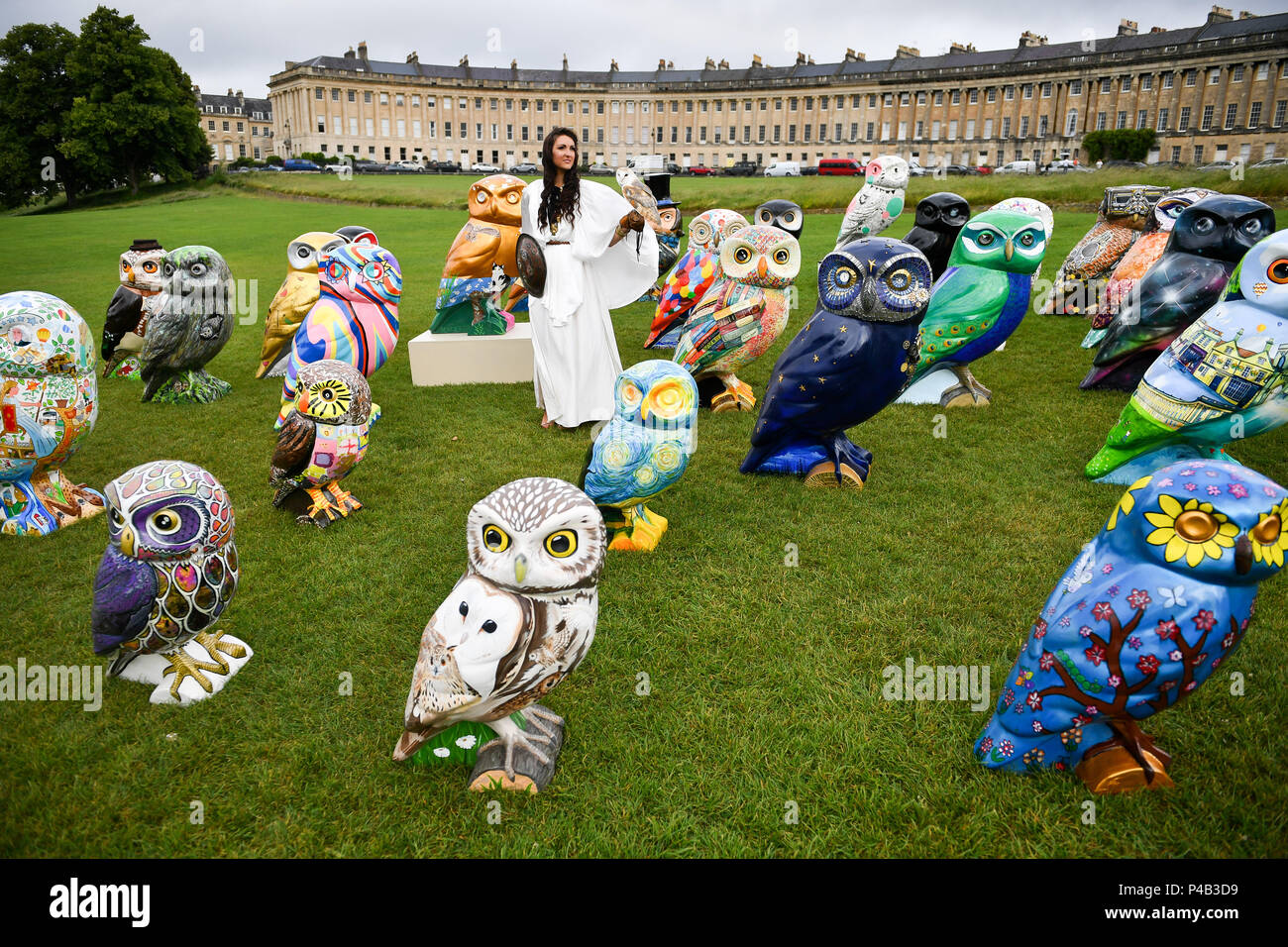 Una Donna vestita come dea romana Minerva, spesso denominato "gufo di Athena" o "gufo di Minerva, sorge con alcuni della Minerva di gufi del bagno di sculture, un sentiero di arte che si svolge intorno alla città per tre mesi a partire dal 25 giugno 2018. Foto Stock