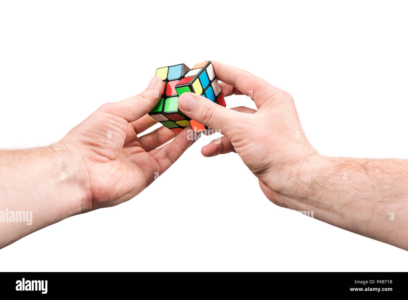 Kharkov, Ucraina - 31 Maggio 2018: Maschio mano che tiene in mano un cubo di Rubik e spin uno dei suoi lati, isolata su uno sfondo bianco, in prima persona Foto Stock