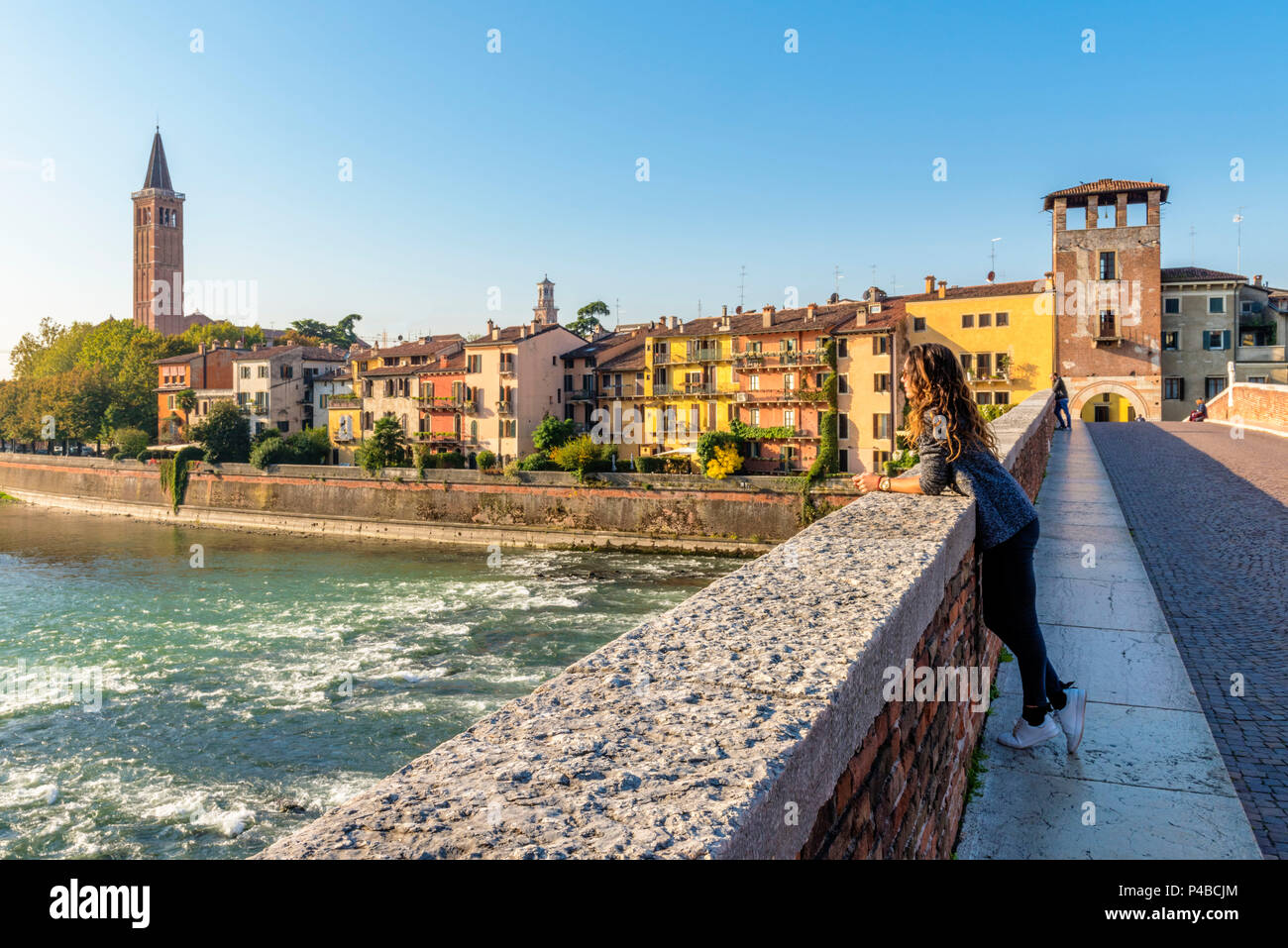 Tourist ammirando il panorama della città vecchia di Verona dal Ponte Pietra. Verona, Veneto, Italia Foto Stock