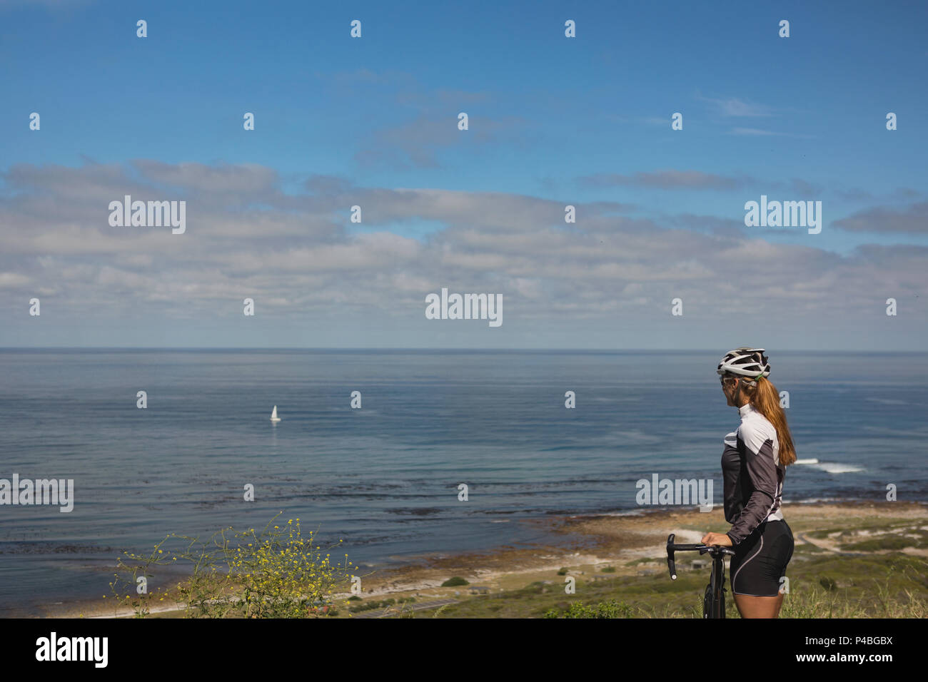 Biker femmina con mountain bike cercando in mare Foto Stock