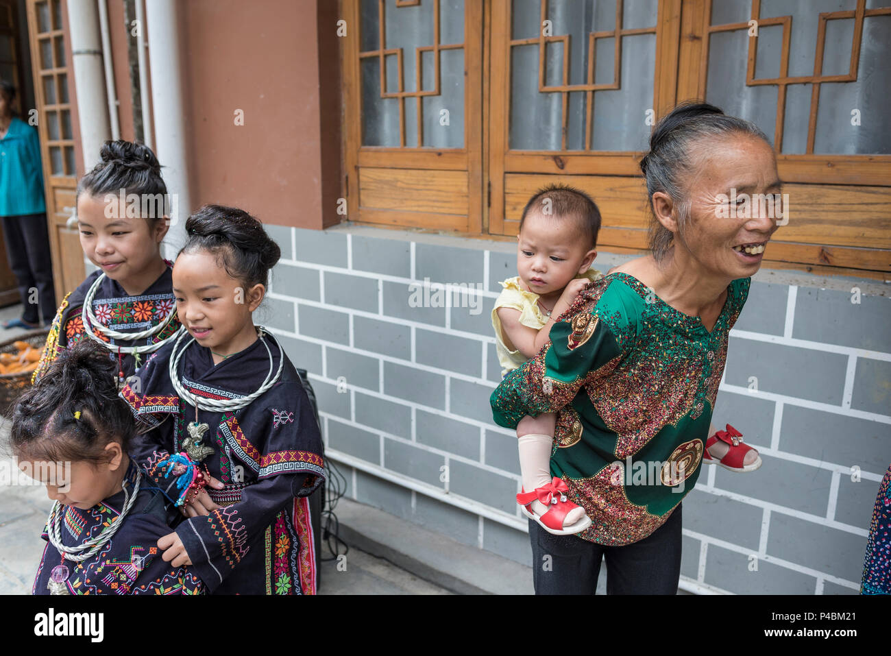 Multi famiglia generazionale in costumi tradizionali, Yao minoranza etnica village, Maolan Lu, Libo, Quizhou Provincia, Cina Foto Stock