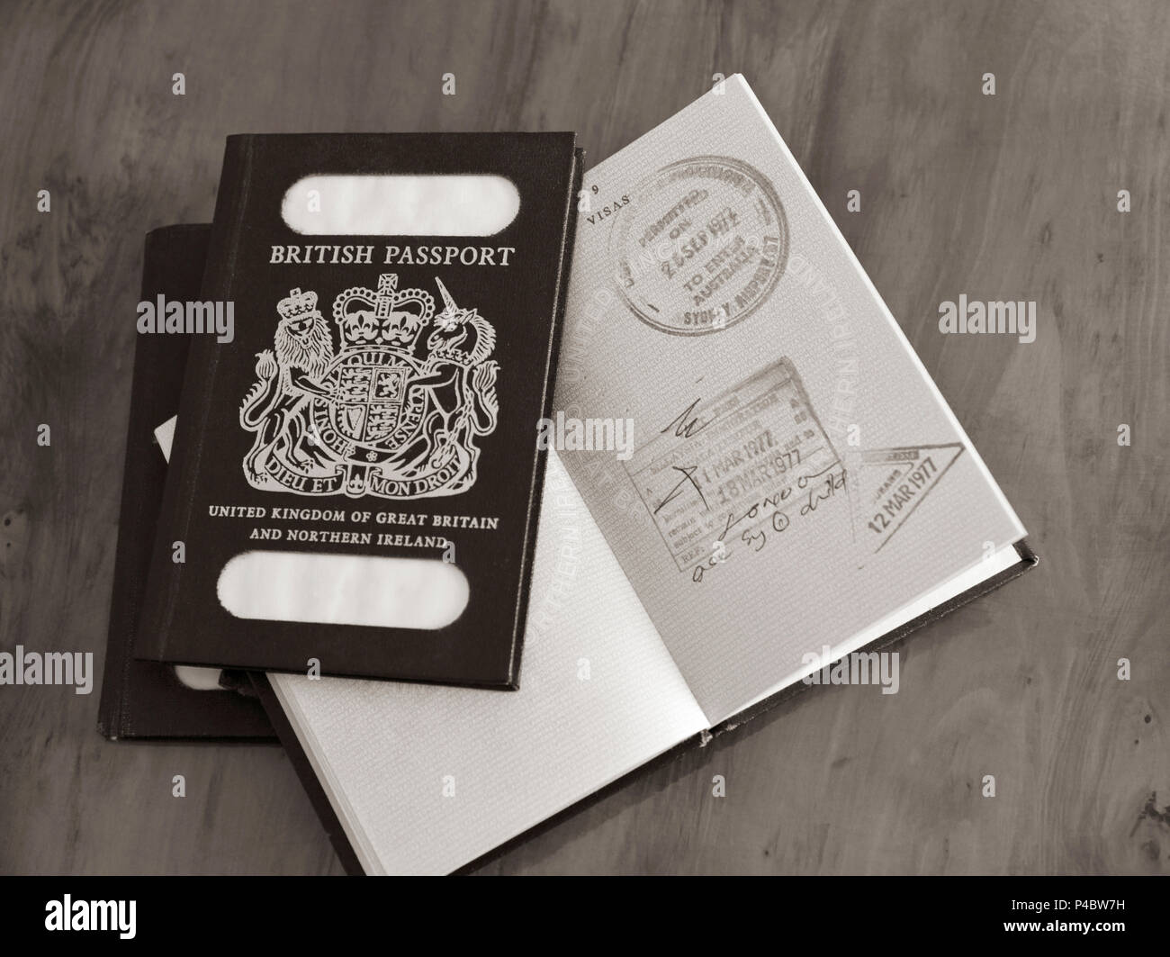 Blu passaporti britannici con una aperta con entrata e uscita timbri illustrato sulla antica scrivania in seppia Foto Stock