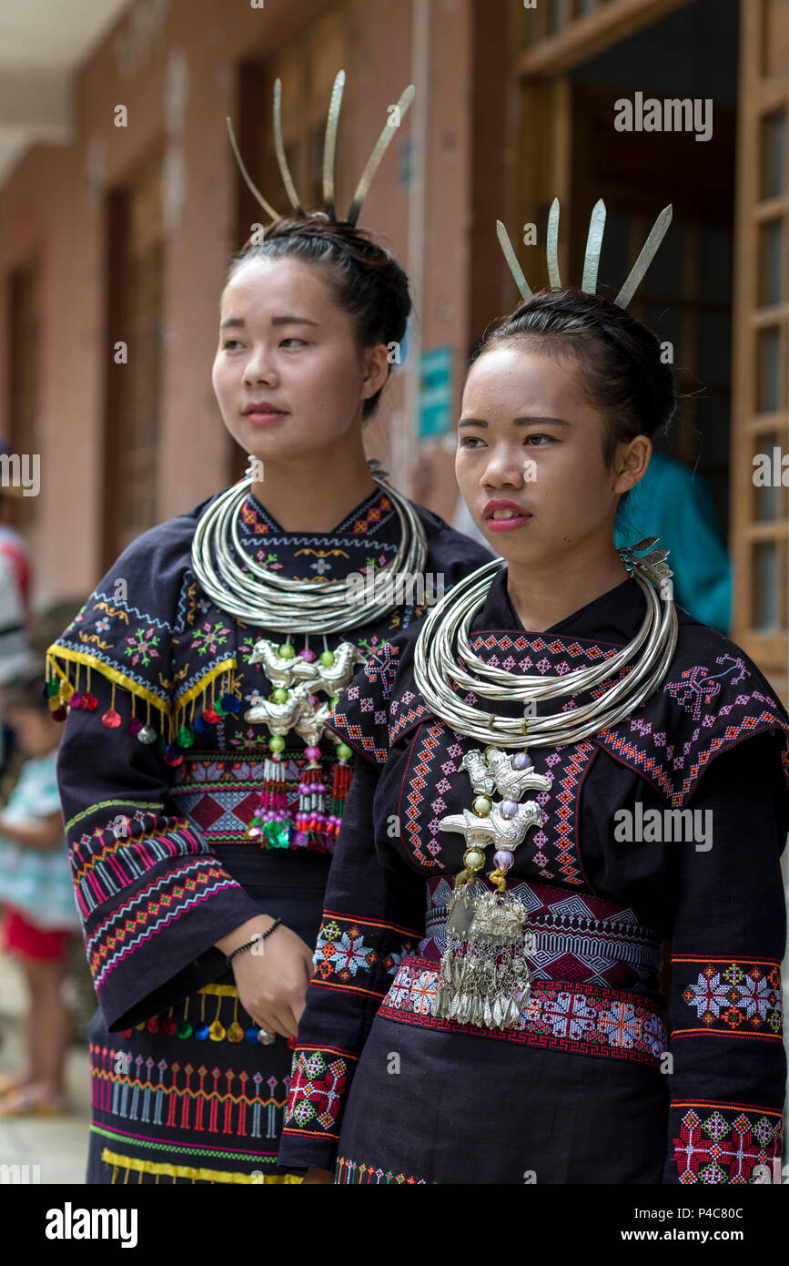 Teen ragazze indossare vestiti pesanti collane argenteo, Yao minoranza etnica village Maolan Lu, Libo, Guizhou, Cina Foto Stock