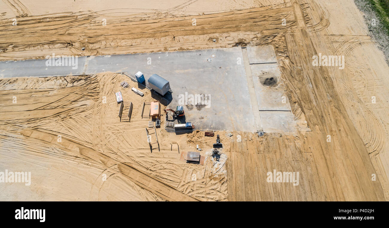 Completato dead-end street in una nuova area di sviluppo, come stoccaggio provvisorio per macchinari da costruzione, dei materiali di costruzione e di costruzione di un carro con m Foto Stock