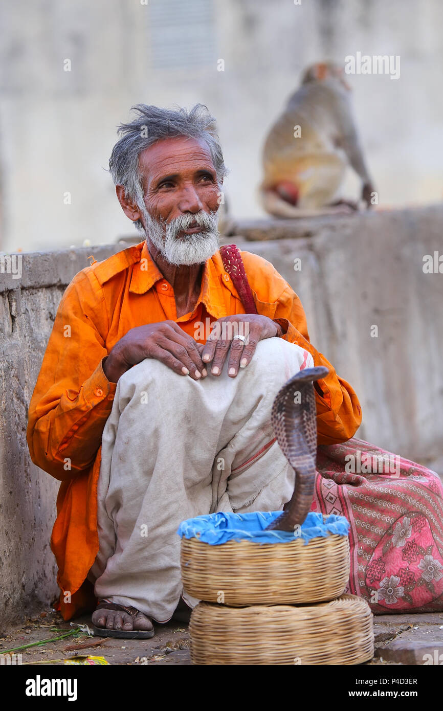 Local snake incantatore seduta in strada di Jaipur, India. Jaipur è il capitale e la più grande città dello stato indiano del Rajasthan. Foto Stock