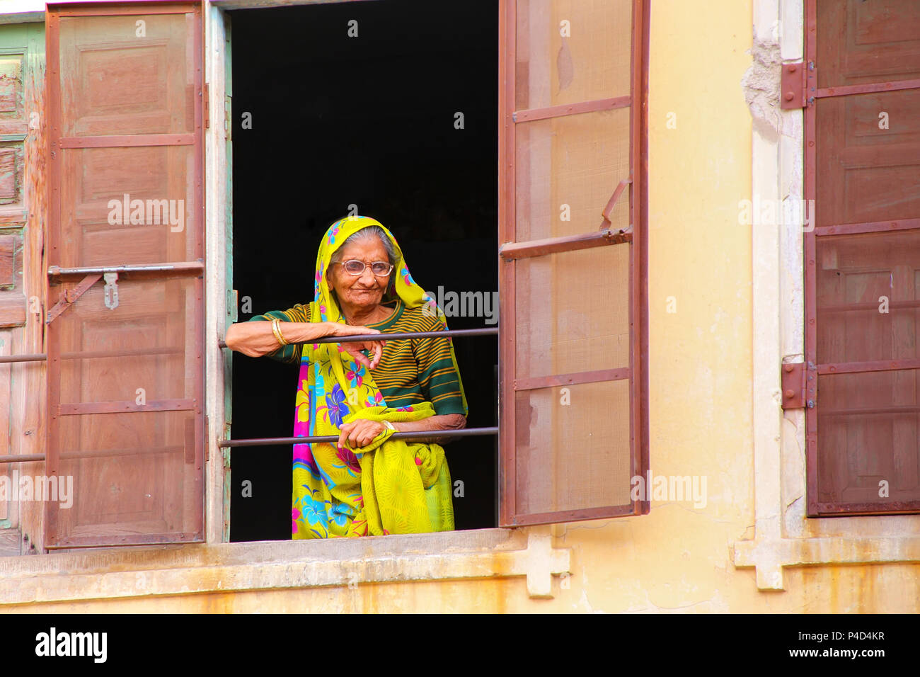 Donna locale guardando fuori della finestra a Jaipur, Rajasthan, India. Jaipur è la capitale e la città più grande del Rajasthan. Foto Stock