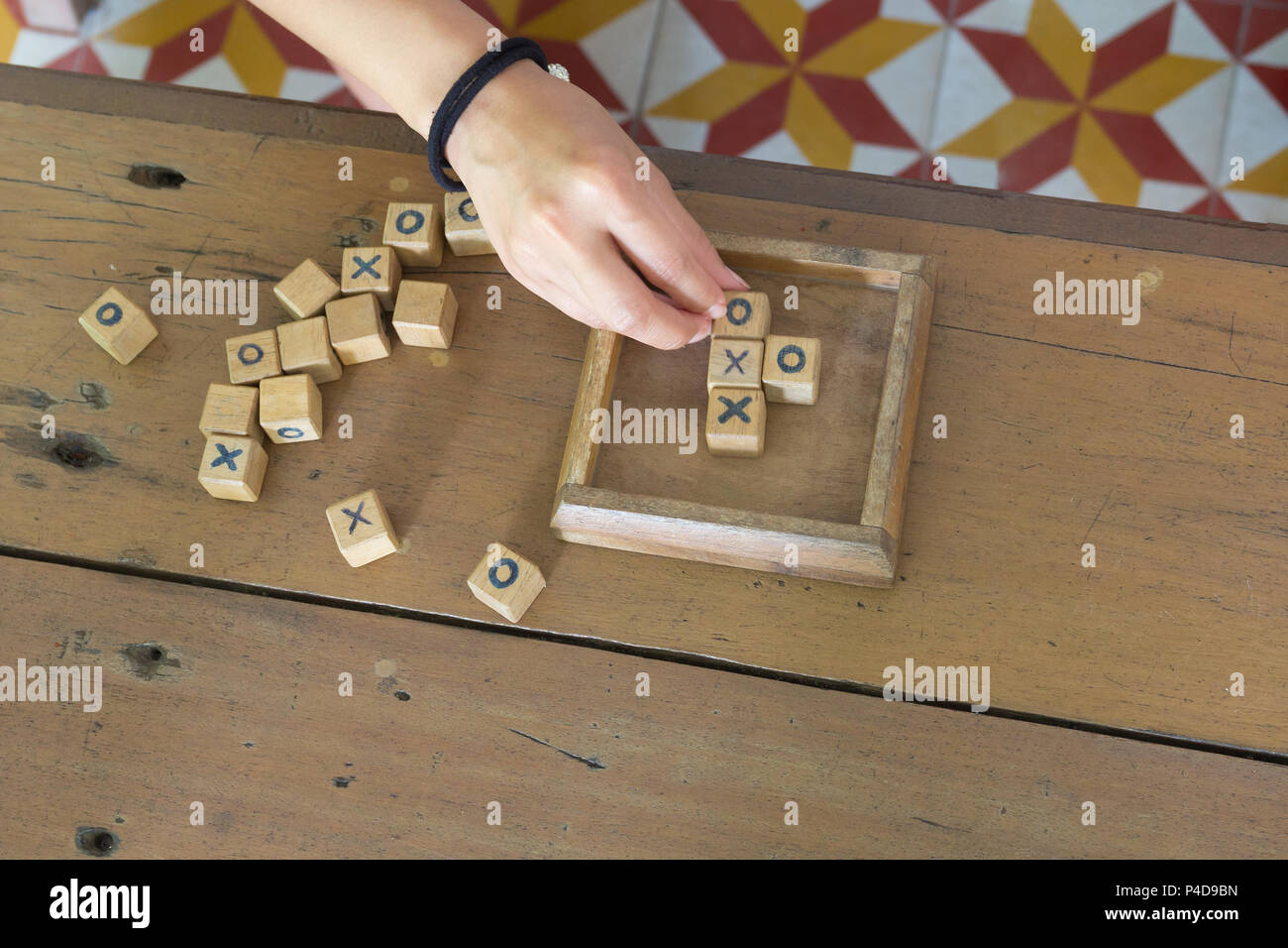 Giocattolo di legno è xo gioco, con lettore a mano sul tavolo di legno dello sfondo. Foto Stock