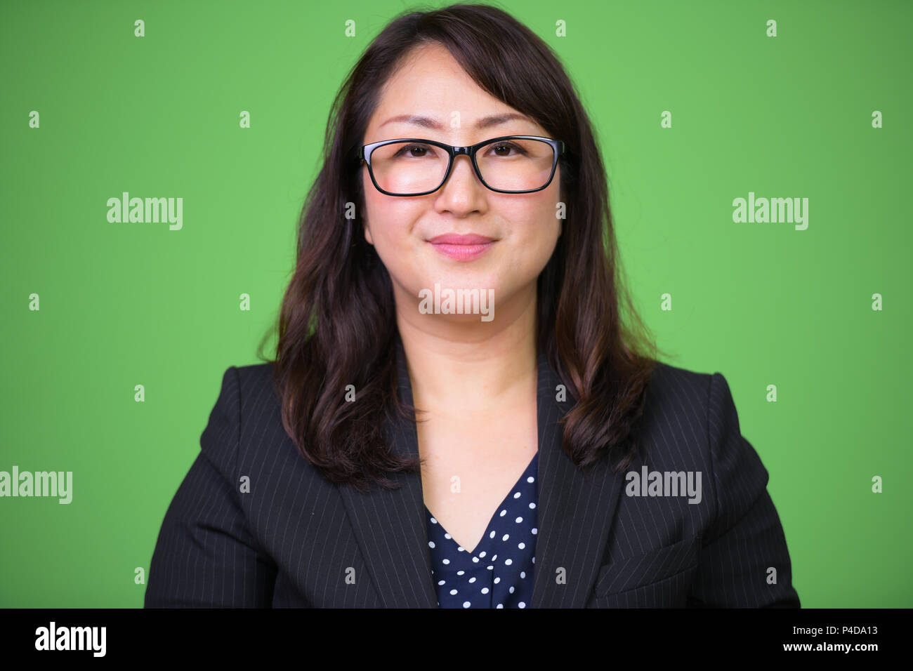 Coppia bella asiatica imprenditrice con occhiali contro lo sfondo di colore verde Foto Stock