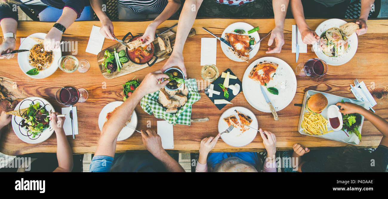 Mangiare e il concetto di tempo libero - gruppo di persone aventi la cena a tavola con i prodotti alimentari Foto Stock