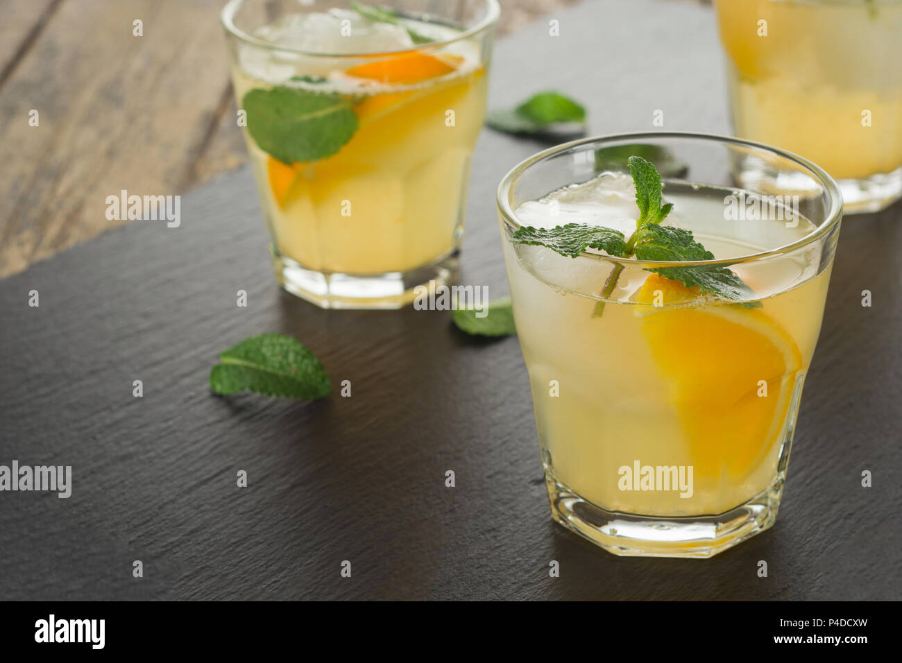 Cocktail. Succo di arancia con la menta e il ghiaccio tavola in legno rustico Foto Stock