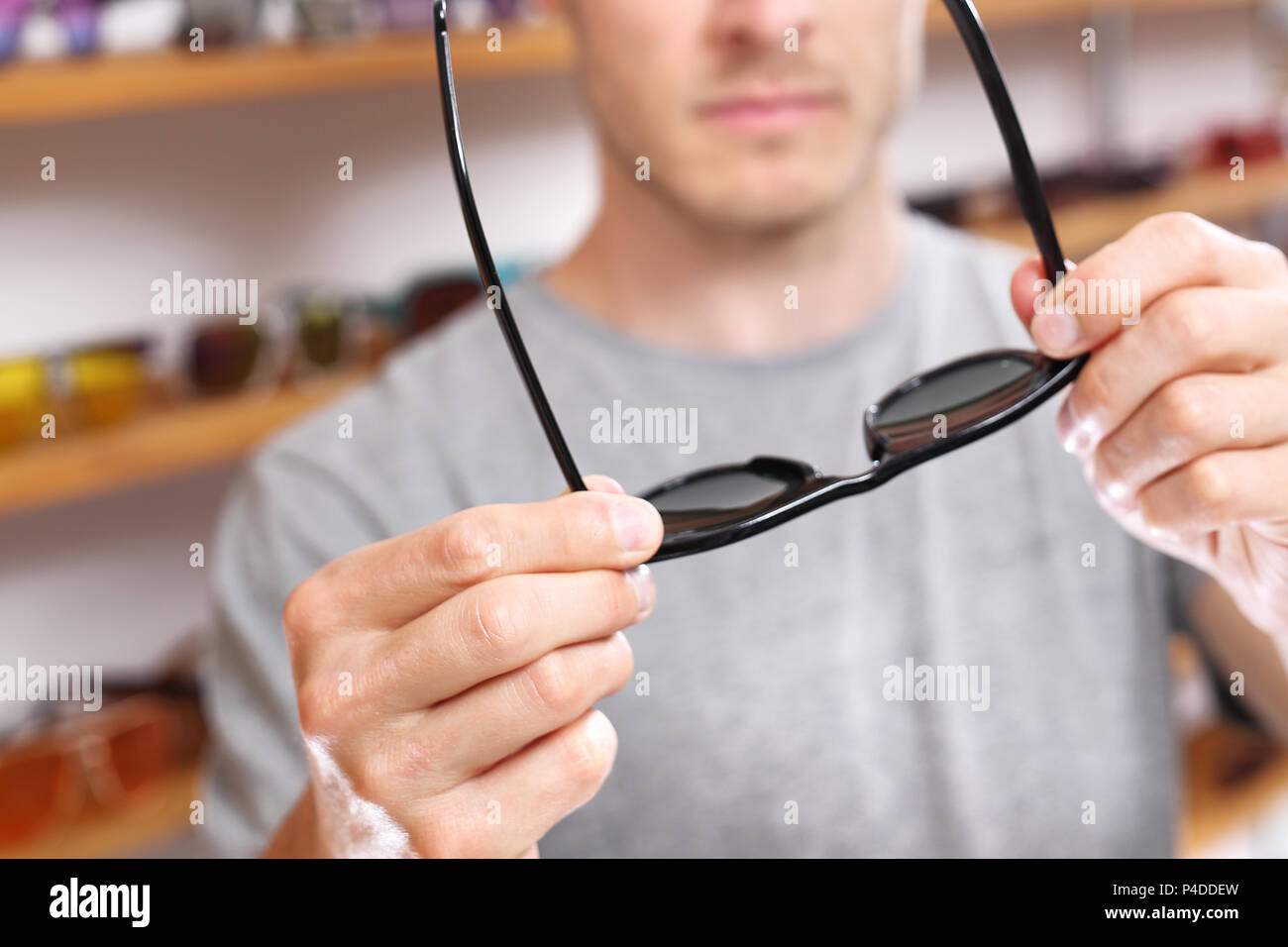 Occhiali da sole. L'uomo sta cercando sui bicchieri. Foto Stock