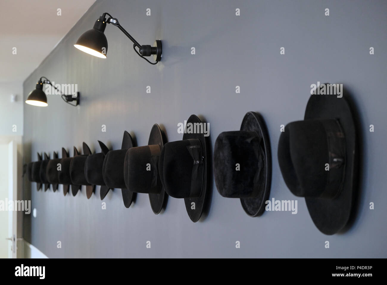Tradizionale cappello nero Haredi appeso su un muro in un corridoio di un edificio di uffici nella città di Bnei Brak o bene Beraq un centro di Haredi giudaismo in Israele Foto Stock