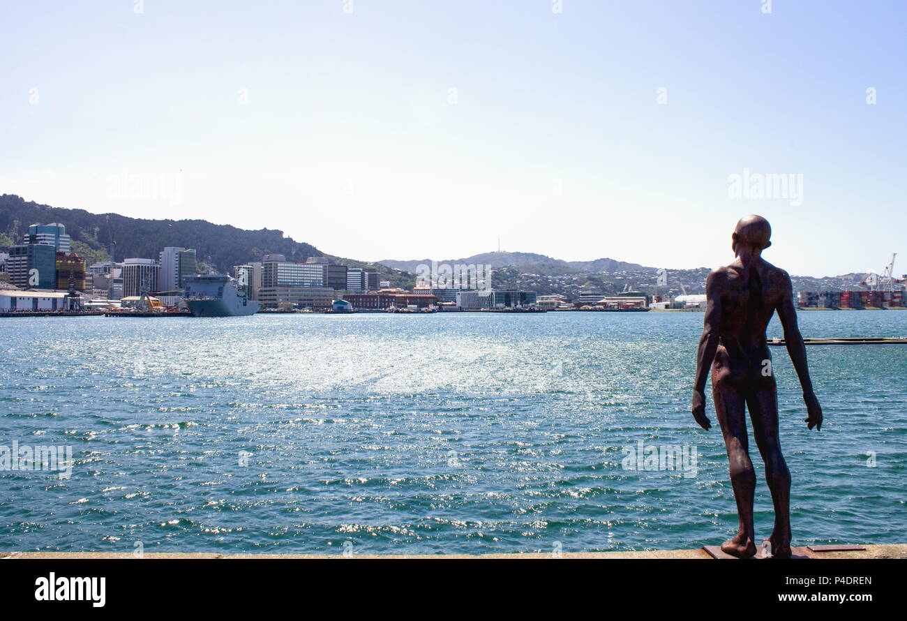 Wellington, Nuova Zelanda - 13 Febbraio 2016: Wellington Harbour su un giorno di estate con patte Max iconici 'Solace nel vento' statua in primo piano Foto Stock