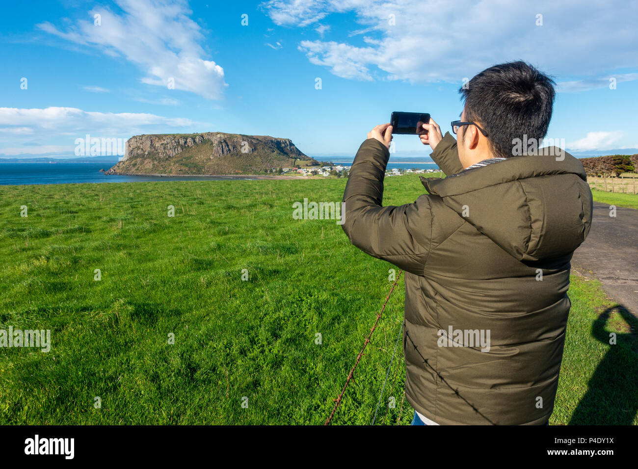 Asian turistica prendendo foto con il telefono mobile della bella vista del paesaggio del dado -- una spina vulcanica a Stanley, Tasmania Australia. Foto Stock