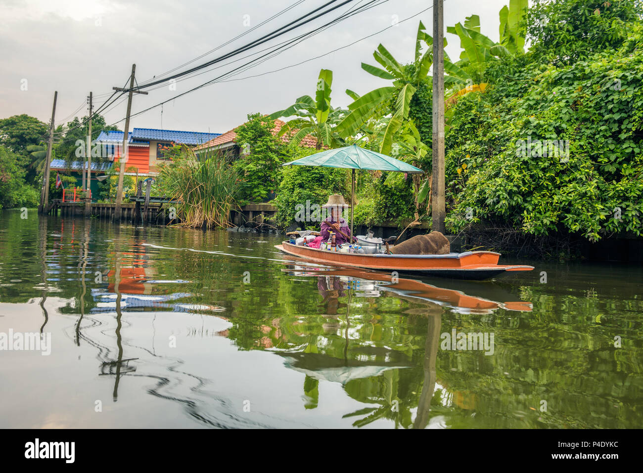 Vecchia donna vende cibo dalla sua barca nei canali di Nonthaburi Foto Stock