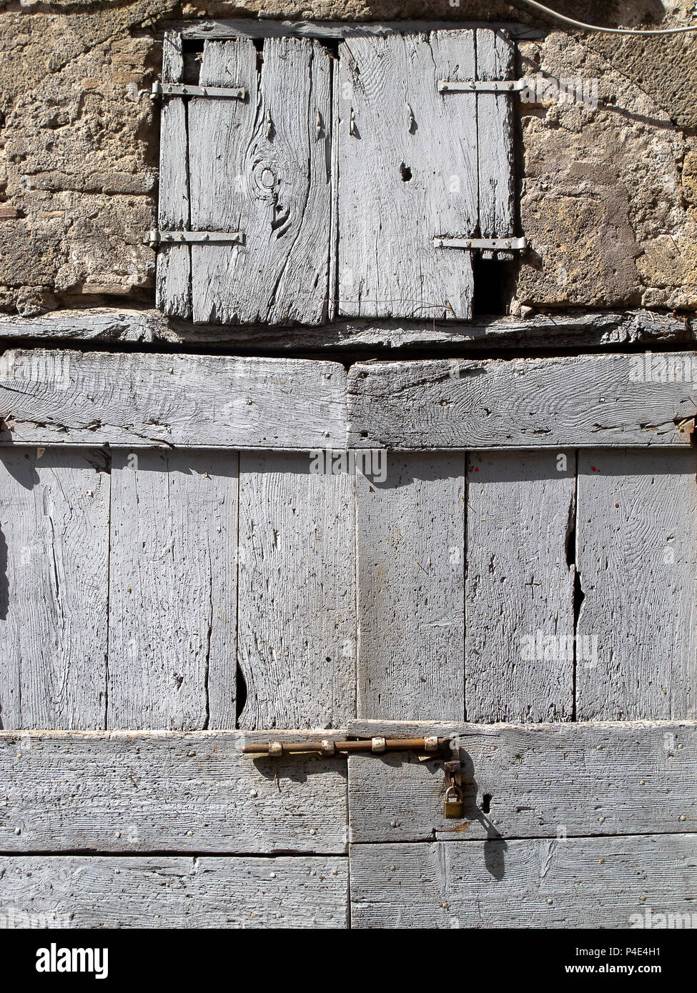 Vecchia porta di legno, con bullone in metallo, la chiusura di una casa di pietra Foto Stock