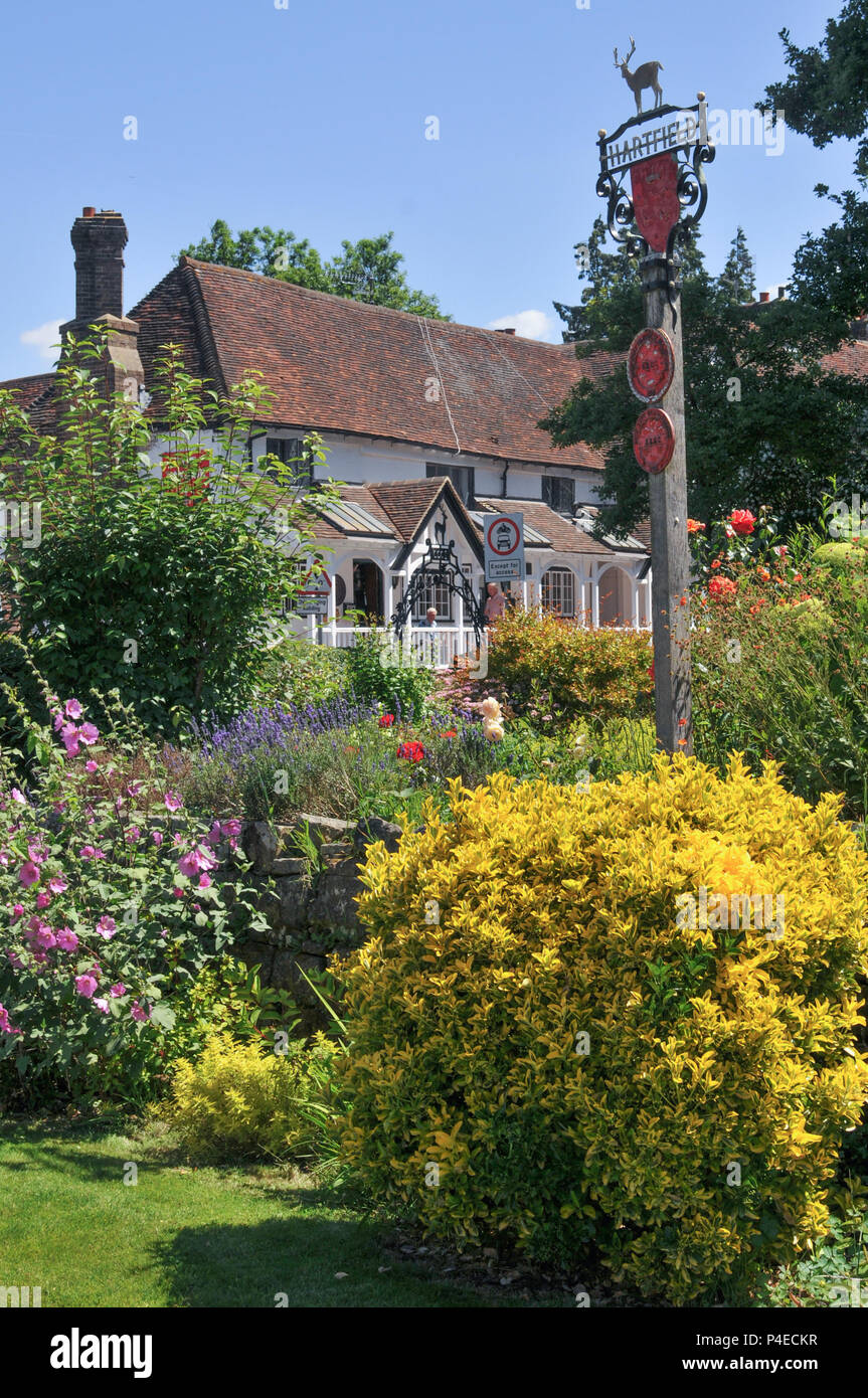 Una vista del villaggio Hartfield segno con fiori in primo piano. Foto Stock