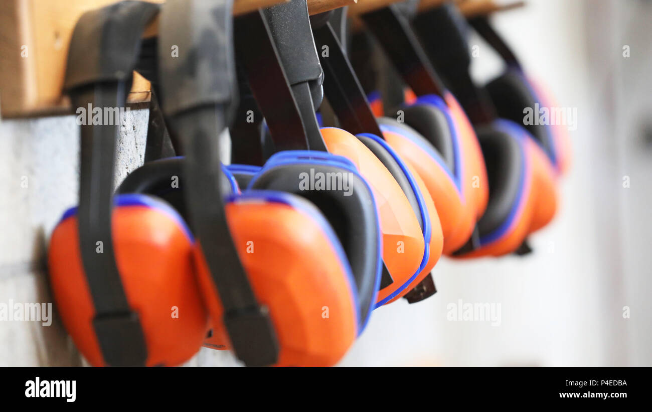 Fila di orange cuffie di protezione per le orecchie su un rack. Salute e  sicurezza sul lavoro la sordità concetto. sicuro pratica di lavoro Foto  stock - Alamy