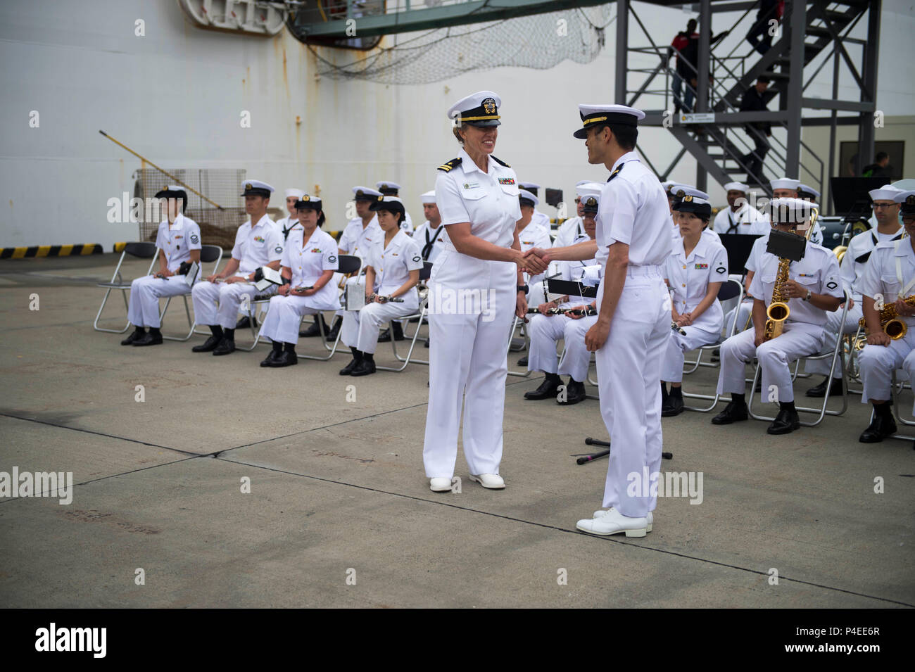 180616-N-VG727-1186 TOKYO (16 giugno 2018) -- STATI UNITI Navy Lt. Kelly Cartwright, conduttore di U.S. Flotta del Pacifico Band, scuote le mani con il Giappone marittimo Forza di Autodifesa (JMSDF) Tenente j.g. K. Honda, conduttore della JMSDF Yokosuka banda, come le bande di giocare insieme durante una cerimonia di benvenuto per i militari di comando Sealift nave ospedale USNS misericordia (T-AH 19) dopo l'arrivo della nave in Tokyo. La misericordia è rendere visite porta a Yokosuka e Tokyo per promuovere le relazioni tra gli Stati Uniti I marinai della marina militare e cittadini giapponesi attraverso lo scambio culturale e di formazione bilaterali. (U.S. Foto di Marina di Massa Comm Foto Stock