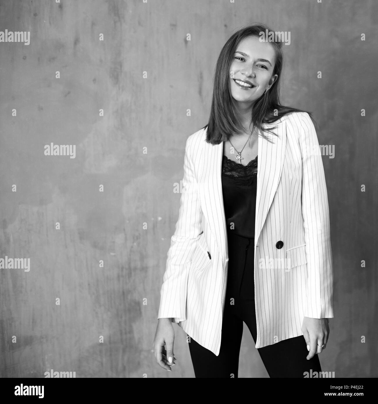 Giovane bella donna graziosa con lunghi capelli dritti indossa Blusa nera e  pantaloni a strisce bianche e camicia ridendo, sorridenti e in posa e  piedistallo Foto stock - Alamy