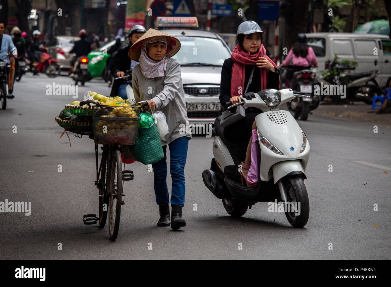 Hanoi, Vietnam - Marzo 16, 2018: Senior lady vendono frutti sulla strada con la sua bicicletta Foto Stock